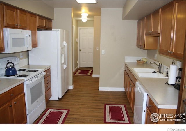 5750 W 20th St Unit 17-2, Greeley, CO 80634 - kitchen featuring a sink, baseboards, white appliances, brown cabinets, and dark wood-type flooring