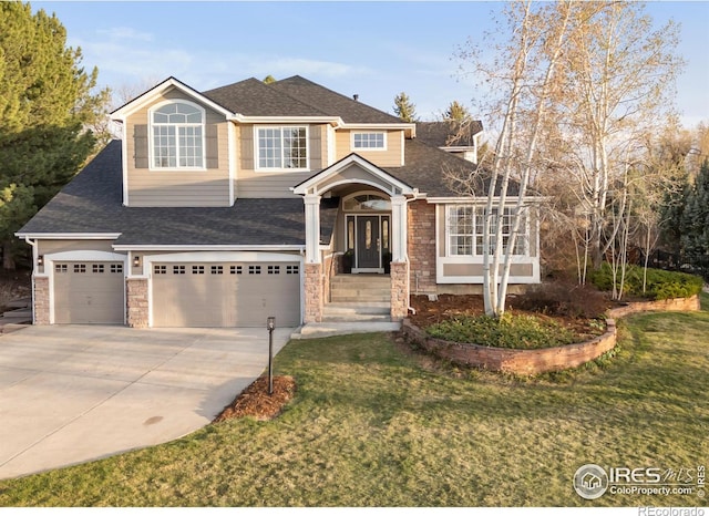 view of front of property featuring a shingled roof, a front lawn, an attached garage, driveway, and stone siding