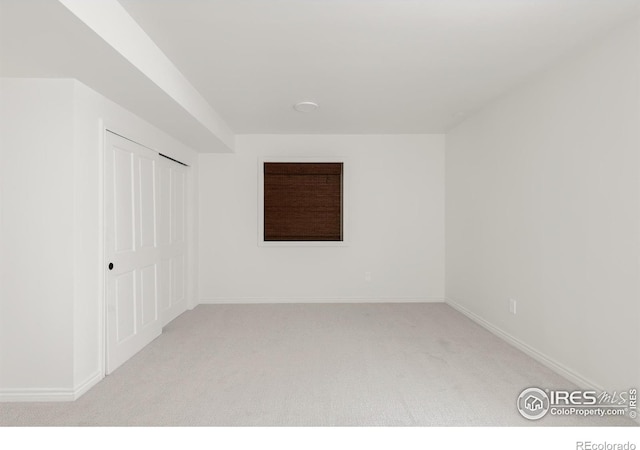 carpeted empty room featuring baseboards