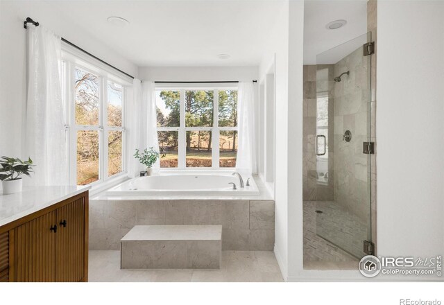 full bathroom with tile patterned floors, a garden tub, vanity, and a shower stall
