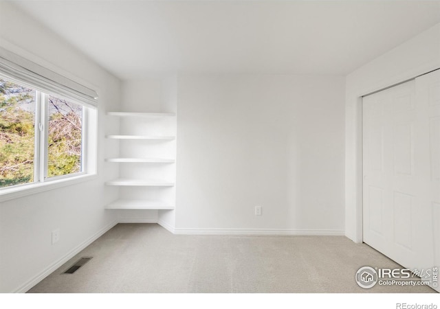 unfurnished bedroom featuring carpet floors, visible vents, and baseboards