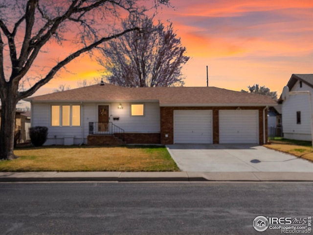 ranch-style home with driveway, a garage, and a lawn
