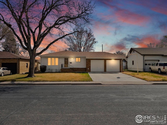 view of front of home featuring a lawn, a garage, and concrete driveway