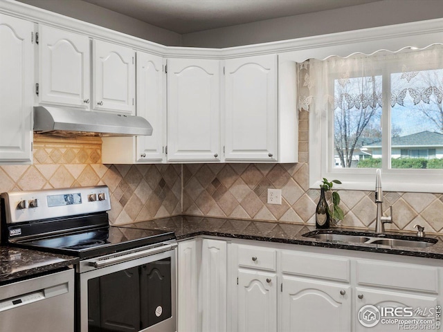 kitchen with a sink, white cabinetry, under cabinet range hood, dark stone countertops, and stainless steel appliances