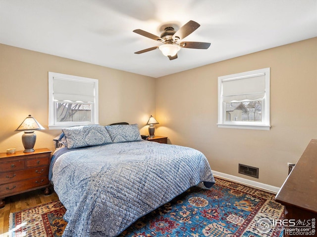 bedroom with baseboards, visible vents, wood finished floors, and ceiling fan