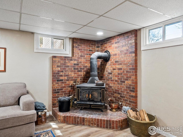 details featuring wood finished floors, a wood stove, and a paneled ceiling