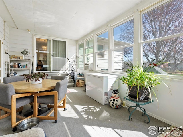 sunroom featuring carpet floors and outdoor dining space