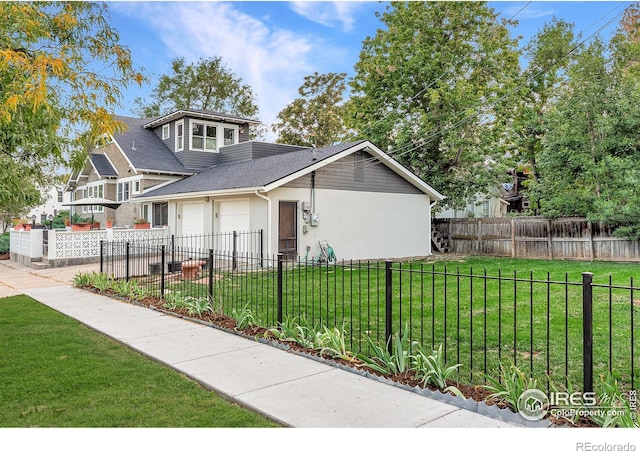 view of front of home featuring driveway, a front yard, stucco siding, an attached garage, and a fenced front yard