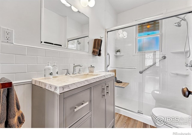 full bathroom with toilet, a stall shower, vanity, and tasteful backsplash