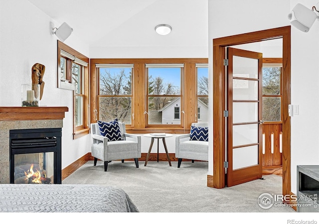 carpeted bedroom featuring baseboards, vaulted ceiling, and a multi sided fireplace