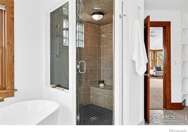 full bath with a shower stall and a soaking tub