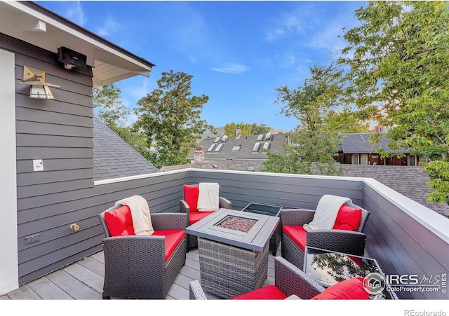 deck with an outdoor living space with a fire pit