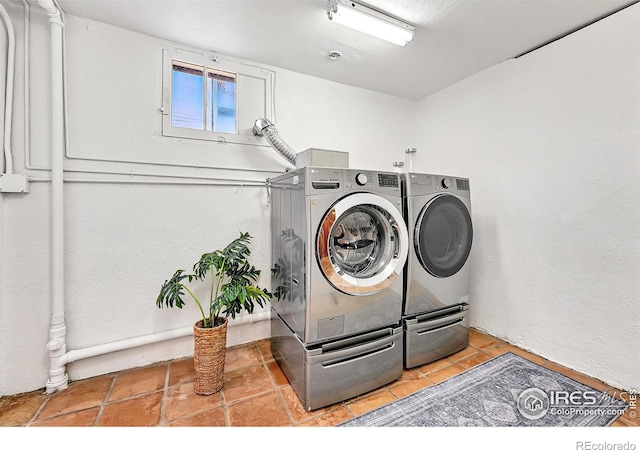 washroom featuring washer and clothes dryer, laundry area, and tile patterned flooring
