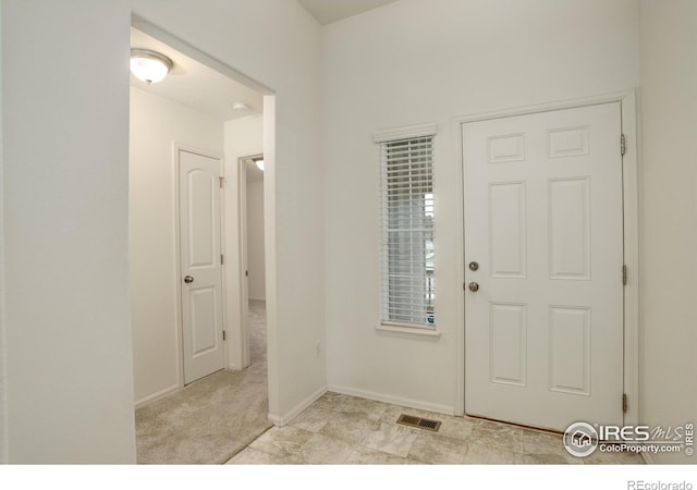 foyer entrance featuring visible vents and baseboards