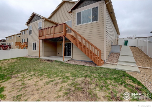 back of house featuring a fenced backyard, a wooden deck, stairway, a yard, and a patio