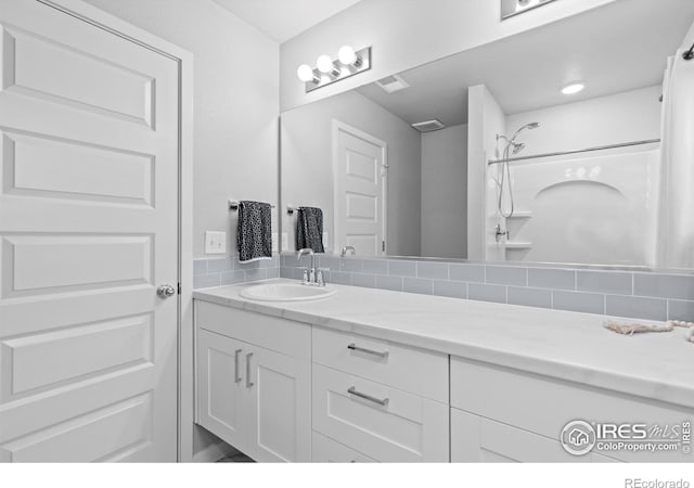 702 S Fulton Ave, Fort Lupton, CO 80621 - full bath featuring vanity, a shower, and backsplash