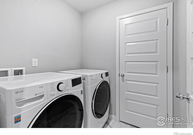 702 S Fulton Ave, Fort Lupton, CO 80621 - washroom with washer and clothes dryer and light marble finish flooring