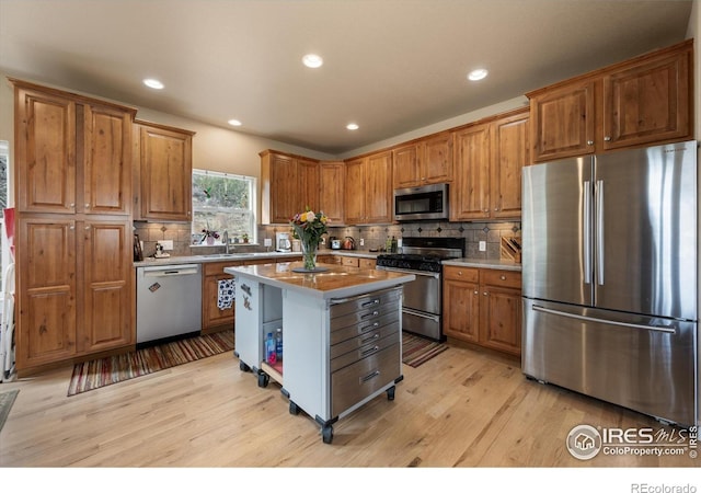 229 Rustic Rd, Bellvue, CO 80512 - kitchen with appliances with stainless steel finishes, light wood-style flooring, backsplash, brown cabinetry, and recessed lighting