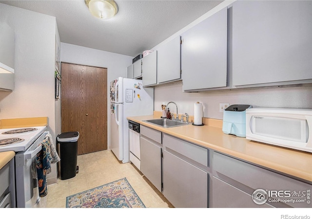 4501 E Boardwalk Dr Unit A9, Fort Collins, CO 80525 - kitchen featuring light countertops, a textured ceiling, a sink, and white appliances