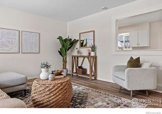 living area featuring baseboards and wood finished floors