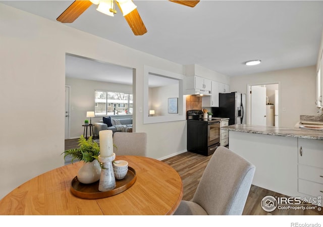 dining area featuring baseboards, ceiling fan, and wood finished floors