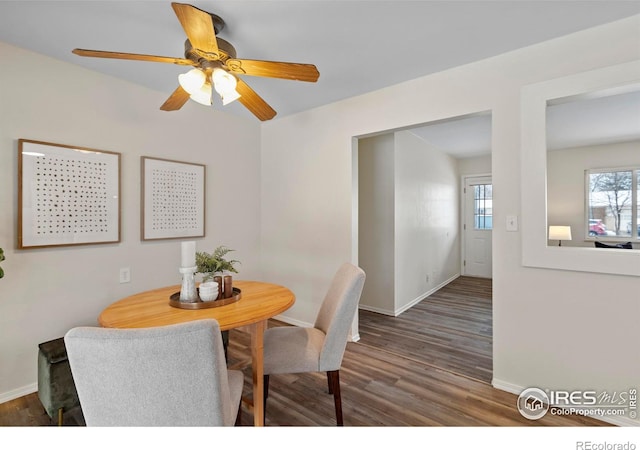 dining space featuring baseboards, ceiling fan, and wood finished floors