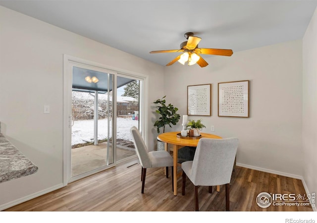 dining space with baseboards, light wood-style floors, and ceiling fan