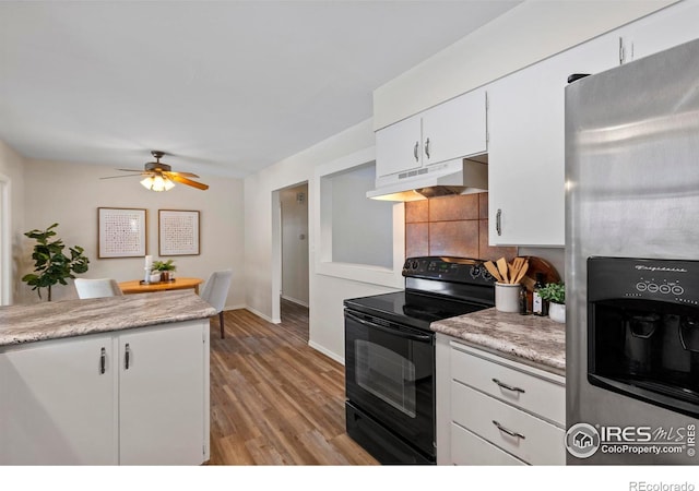kitchen with light countertops, under cabinet range hood, stainless steel refrigerator with ice dispenser, white cabinets, and black / electric stove