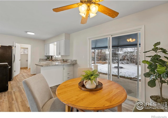 dining area featuring light wood-type flooring and ceiling fan