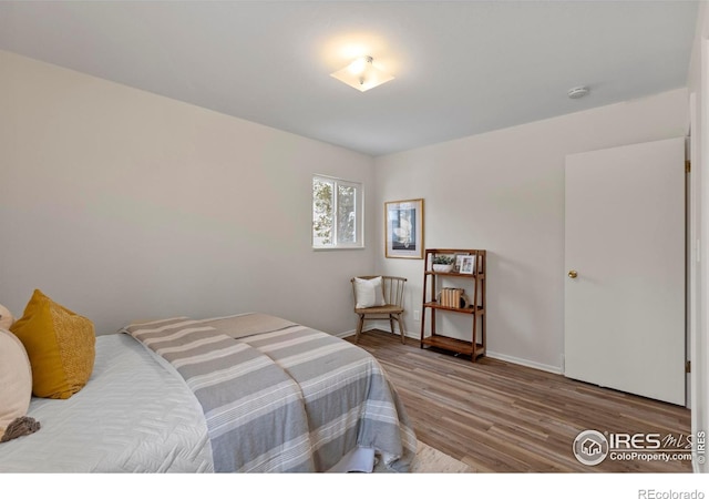 bedroom with baseboards and wood finished floors