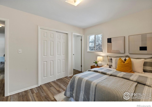bedroom with baseboards, a closet, and wood finished floors