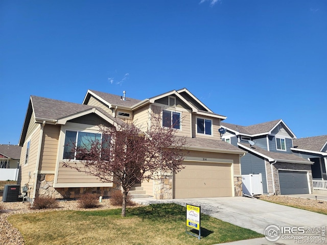 214 Castle Dr, Severance, CO 80550 - craftsman house featuring stone siding, a garage, a front yard, central air condition unit, and driveway