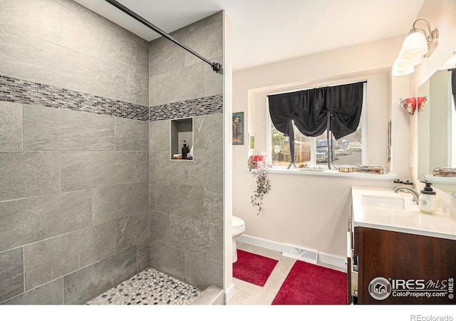 9331 Irving St, Westminster, CO 80031 - bathroom with vanity, toilet, baseboards, tile patterned floors, and tiled shower
