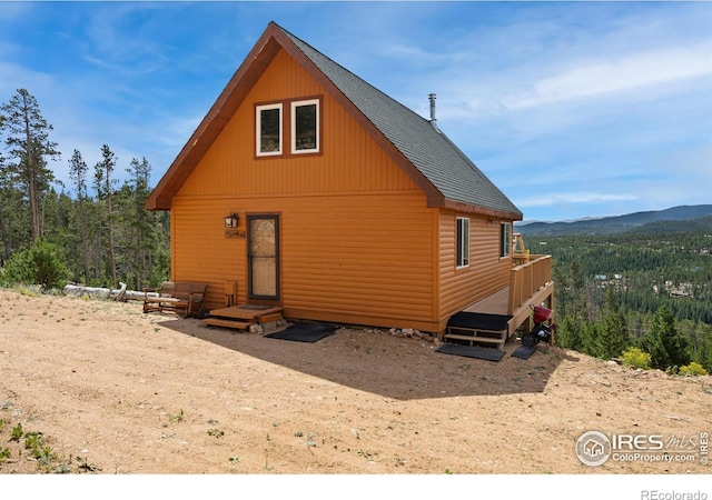 160 Shuswap Ct, Red Feather Lakes, CO 80545 - back of property with a view of trees, roof with shingles, and a mountain view