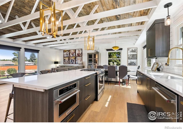 2017 Harmony Dr, Fort Collins, CO 80525 - kitchen with light countertops, a chandelier, a sink, light wood-style flooring, and appliances with stainless steel finishes