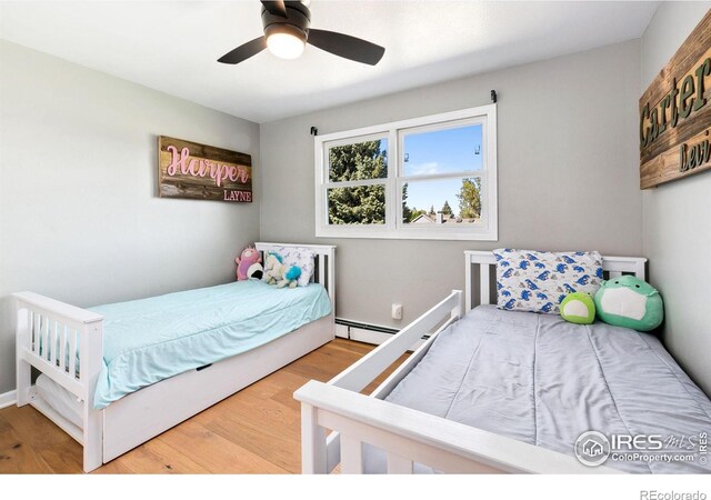 2017 Harmony Dr, Fort Collins, CO 80525 - bedroom featuring a ceiling fan, a baseboard heating unit, and wood finished floors