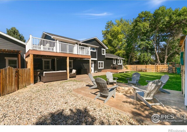 2017 Harmony Dr, Fort Collins, CO 80525 - rear view of house with a patio area, fence, a deck, an outdoor living space with a fire pit, and a yard