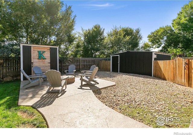 2017 Harmony Dr, Fort Collins, CO 80525 - view of yard featuring a fire pit, a patio area, an outbuilding, a fenced backyard, and a storage unit