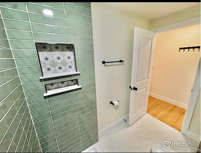 bathroom with baseboards and tile patterned flooring