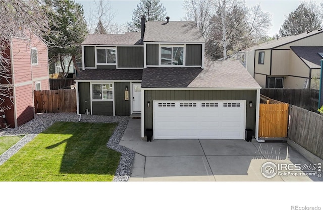 traditional home featuring a front yard, fence, a shingled roof, and driveway