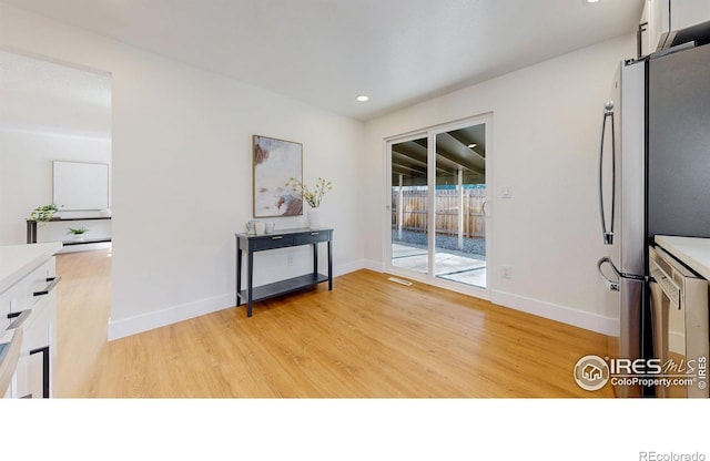 unfurnished dining area featuring light wood-type flooring, baseboards, and recessed lighting
