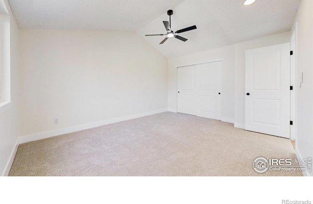 unfurnished bedroom with carpet flooring, baseboards, and vaulted ceiling