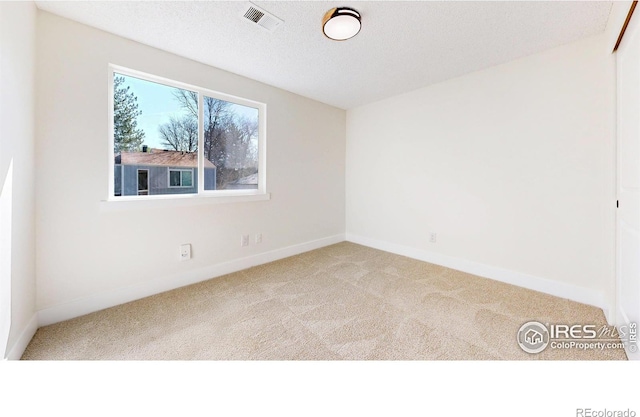 carpeted empty room featuring baseboards and visible vents