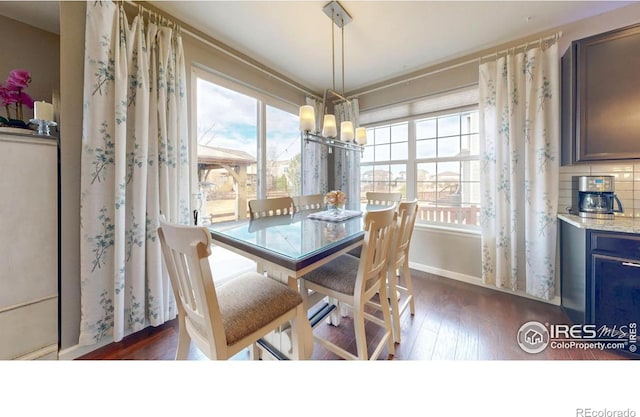 6820 Rainier Rd, Timnath, CO 80547 - dining space featuring healthy amount of natural light, dark wood-style flooring, a chandelier, and baseboards