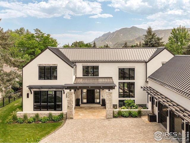 706 Juniper Ave, Boulder, CO 80304 - view of front facade with stone siding, a mountain view, stucco siding, a metal roof, and a standing seam roof