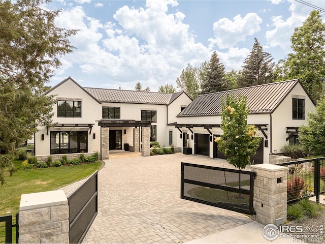 706 Juniper Ave, Boulder, CO 80304 - modern farmhouse style home featuring stucco siding, decorative driveway, a fenced front yard, stone siding, and a standing seam roof