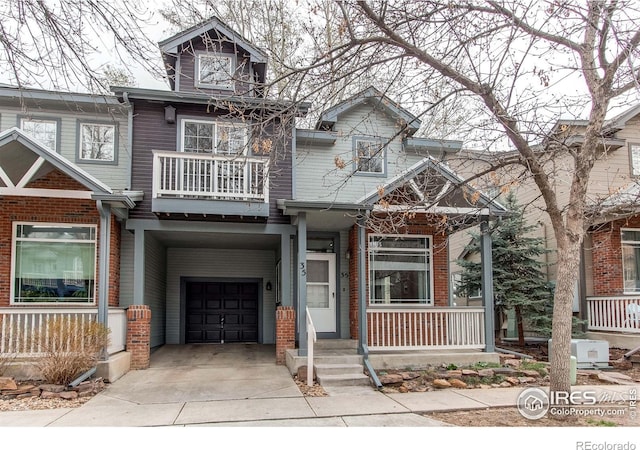 828 Kane Dr Unit 35, Longmont, CO 80501 - view of front facade featuring covered porch, an attached garage, driveway, a balcony, and a carport