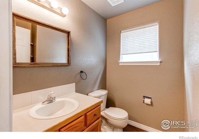 828 Kane Dr Unit 35, Longmont, CO 80501 - bathroom with toilet, vanity, baseboards, and a textured wall