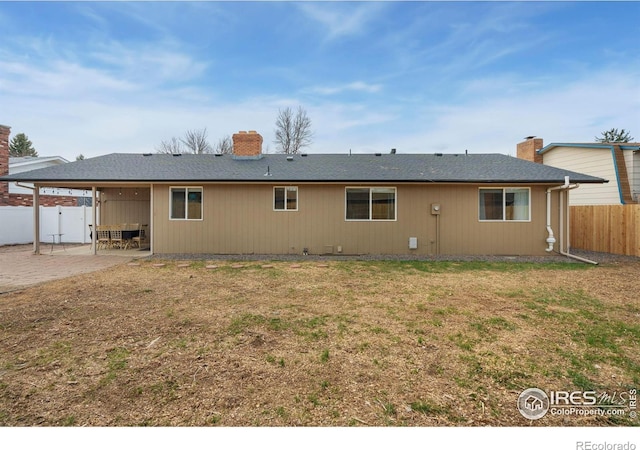 253 Courtney Dr, Loveland, CO 80537 - back of property featuring a patio, fence private yard, a chimney, and a yard