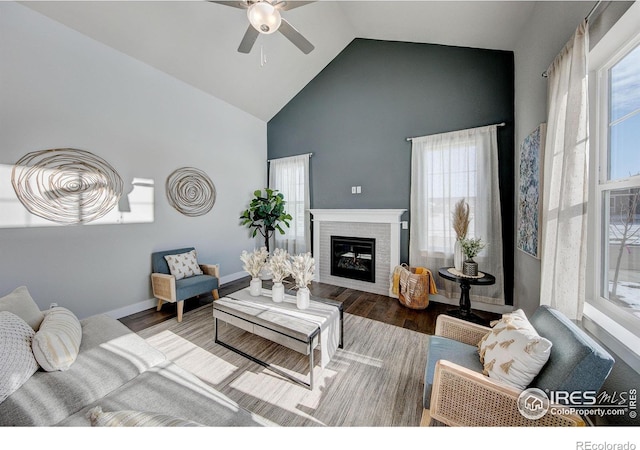 4284 Trapper Lake Dr, Loveland, CO 80538 - living room with high vaulted ceiling, a fireplace, a ceiling fan, wood finished floors, and baseboards
